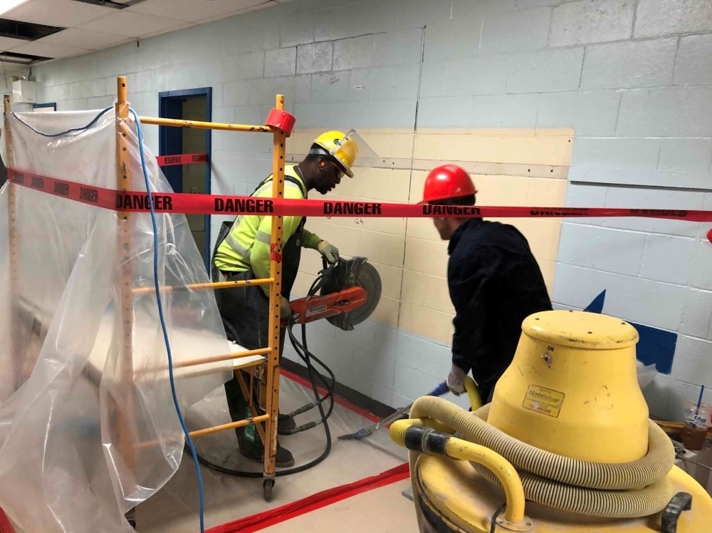 Two crew members performing interior concrete cutting with concrete saw