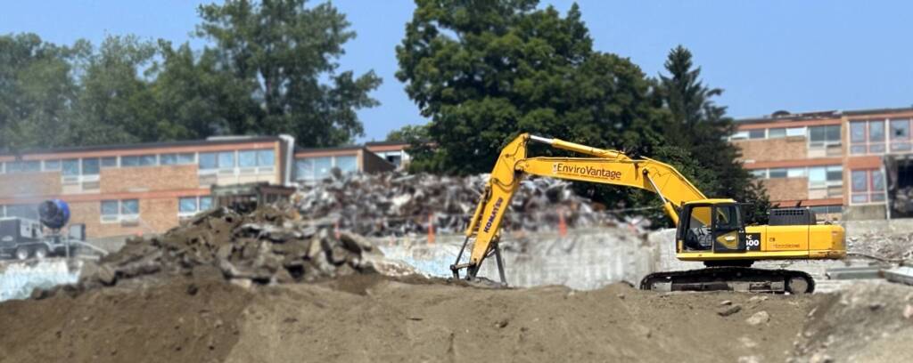 EnviroVantage excavator performing soil remediation at high school campus